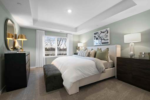 A bedroom with a large bed, a dresser, and a mirror.