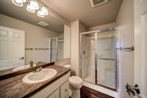 Sliding Glass Shower in Bathroom with White Cabinets
