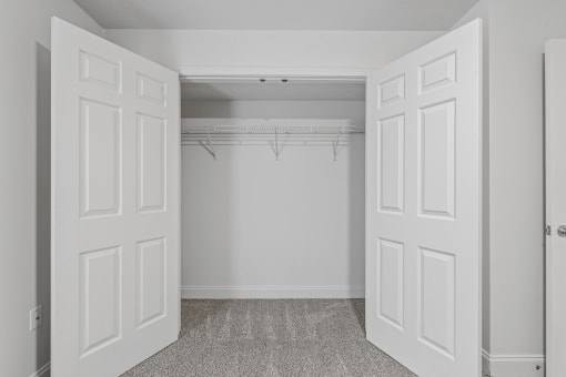 a bedroom with two closets and two doors