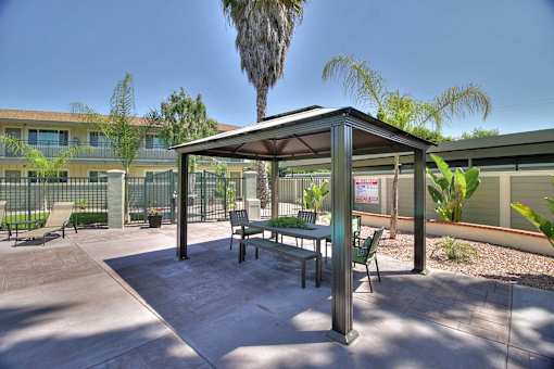 A patio with a table and chairs under a roof.