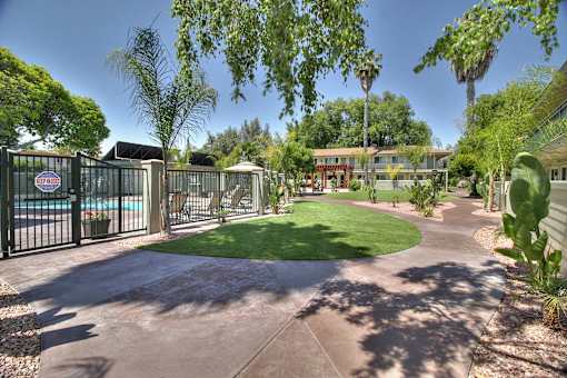 A gated community with a pool and a green lawn.