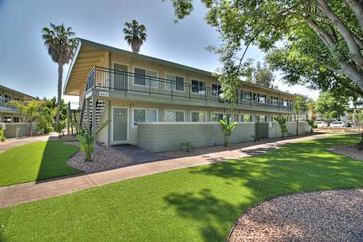 A sunny day at a residential building with a green lawn.