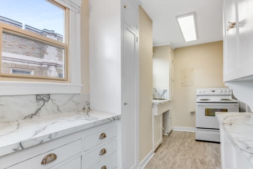 Fully-Equipped Kitchen  with Marble Look Countertops, A Window, and Stove Oven at Malloy Apartment Homes, Seattle, WA