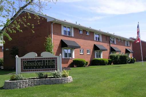 A brick building with a sign that says Rossford Hills Apartment.