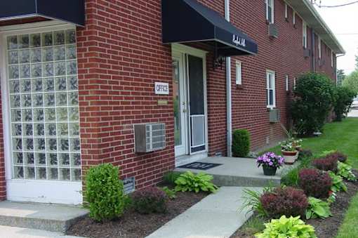 A brick building with a white door and a sign that says