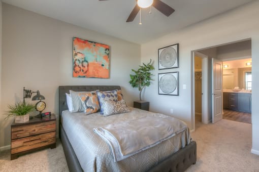 bedroom with ceiling fan and hallway to the bathroom  at EdgeWater at City Center, Lenexa, KS