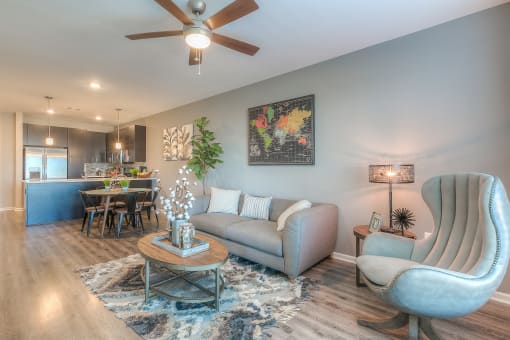a living room with a ceiling fan and chair  at EdgeWater at City Center, Lenexa, Kansas