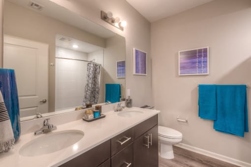 a bathroom with two sinks and a toilet  at EdgeWater at City Center, Lenexa, 66219