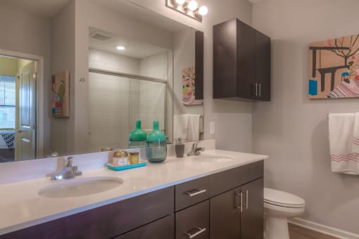 a bathroom with two sinks and a toilet  at EdgeWater at City Center, Kansas, 66219