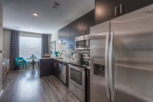 a kitchen with stainless steel appliances and a wooden floor  at EdgeWater at City Center, Lenexa, KS, 66219