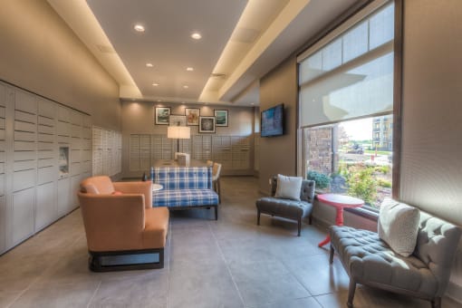 a lounge area with couches chairs and a television  at EdgeWater at City Center, Lenexa, KS