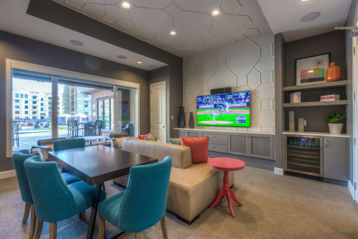 a resident clubhouse with a table and chairs and a flat screen tv  at EdgeWater at City Center, Lenexa, KS, 66219