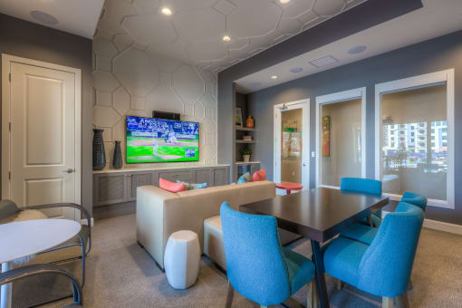 a room with a table and chairs and a tv  at EdgeWater at City Center, Lenexa, KS