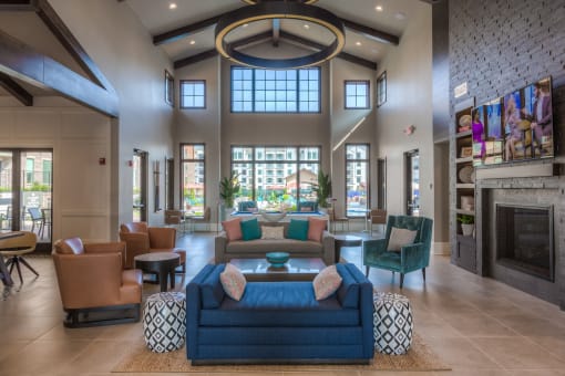 a large living room with couches chairs and a fireplace  at EdgeWater at City Center, Lenexa, Kansas