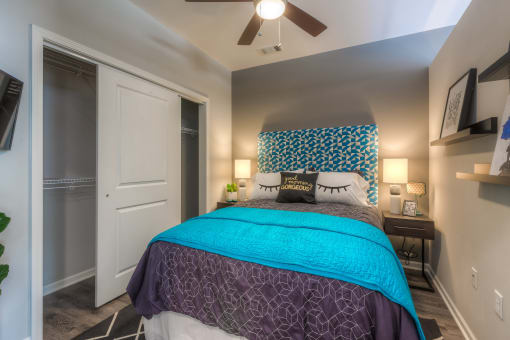 a bedroom with a large bed and a ceiling fan  at EdgeWater at City Center, Lenexa, 66219
