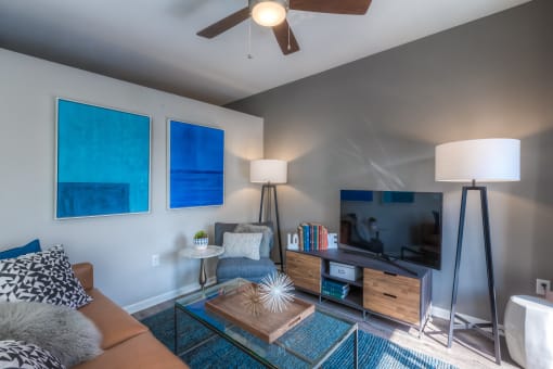 a living room with a ceiling fan and a flat screen tv  at EdgeWater at City Center, Lenexa, Kansas
