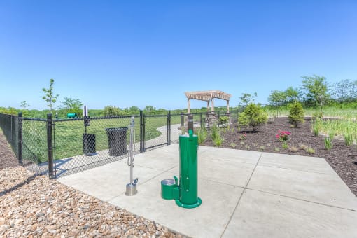 a fenced in area with a water fountain and trash cans  at EdgeWater at City Center, Lenexa, KS, 66219