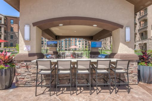 a bar area with grills and flat screen tv's  at EdgeWater at City Center, Lenexa, KS, 66219