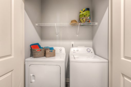 a small laundry room with two washers and a dryer  at Waterside Residences on Quivira, Lenexa, KS