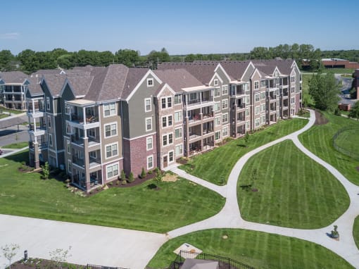 an aerial view of an apartment complex with green grass and trees  at Waterside Residences on Quivira, Kansas