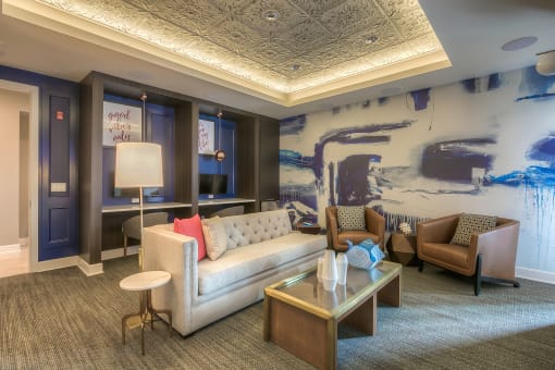 media lounge with work area and seating in front of a tv  at Waterside Residences on Quivira, Lenexa, Kansas
