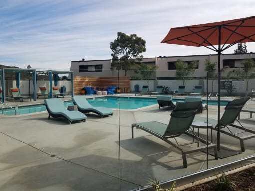 Outdoor pool area with lounge chairs at Mission Trails Apartments San Diego, California