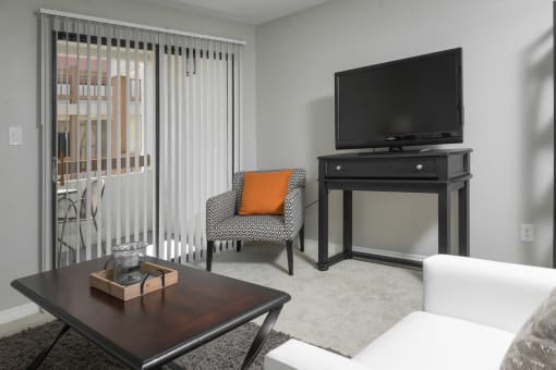Living area with TV and sliding glass doors to balcony at Mission Trails Apartments San Diego, San Diego, 92119