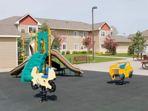 A playground with a slide and a rocking toy car.