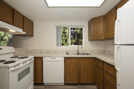 Cozy Kitchen with Wooden Cabinetry and White Appliances at Woodlake Townhomes, Edmonds, 98026
