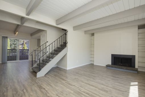Newly Renovated Living Space with Exposed Ceiling Beams, Plank Flooring, a Staircase, and Fireplace at Woodlake Townhomes, Edmonds