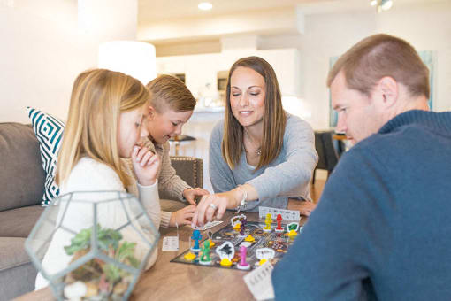 a group of people sitting around a table playing a board game