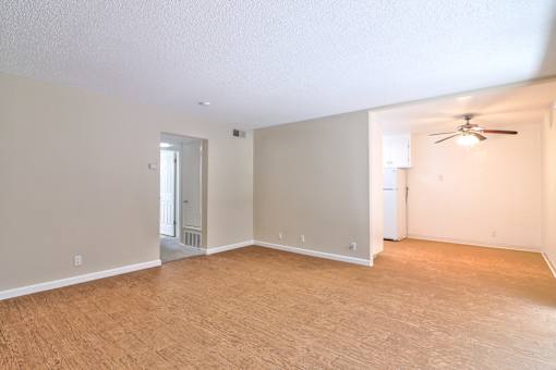 A room with a ceiling fan and a doorway leading to another room.