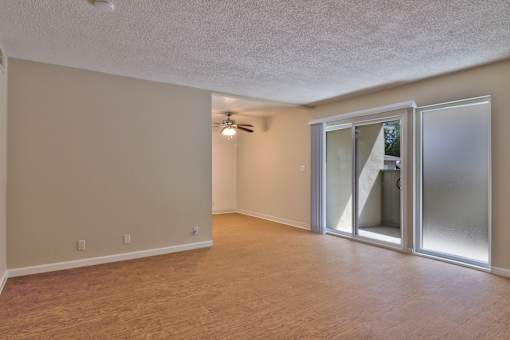 A room with a sliding glass door and a ceiling fan.
