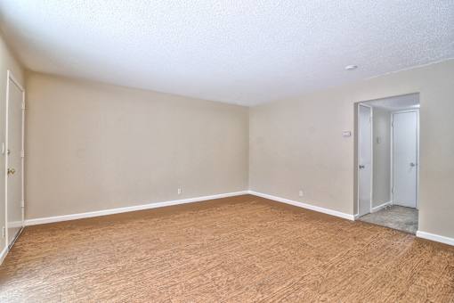 A room with wooden flooring and two doors.