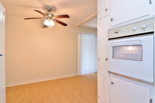 A kitchen with a fan and a microwave oven.