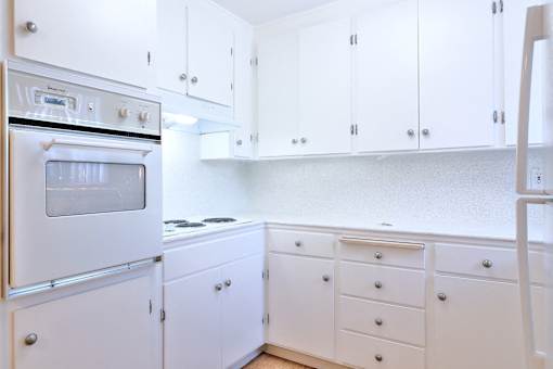 A white kitchen with a stove and oven.