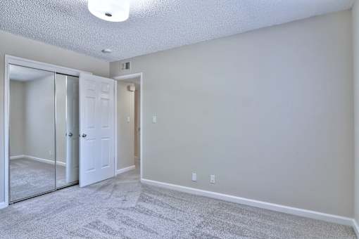 A room with a carpeted floor and a white door.