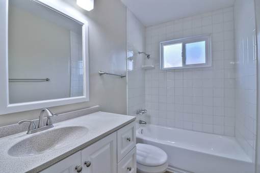 A white bathroom with a sink, toilet, and bathtub.