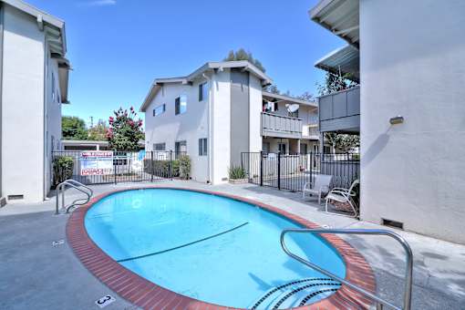 A small pool in a courtyard surrounded by buildings.
