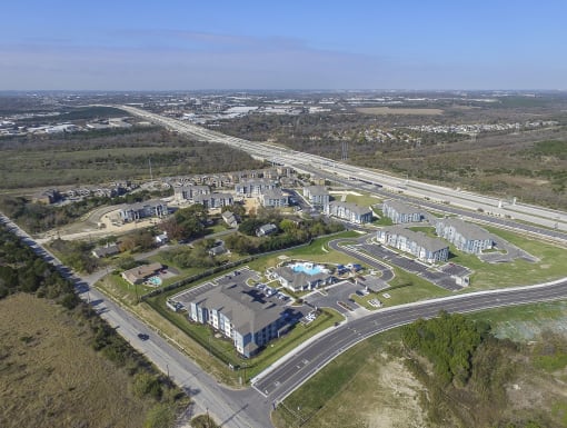 Expansive aerial shot of a residential community with organized buildings, open spaces, and easy connectivity to nearby roads.