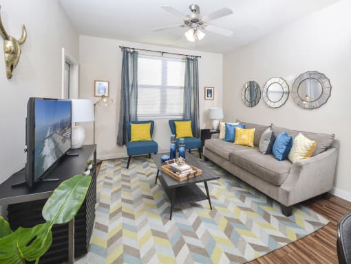 Bright living room with modern furnishings, cozy sofa seating, and stylish accent chairs in a comfortable layout.