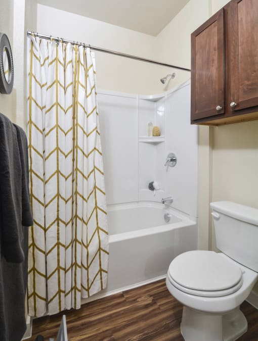 Modern bathroom retreat offering functional design, abundant storage options, and a classic tub/shower arrangement.