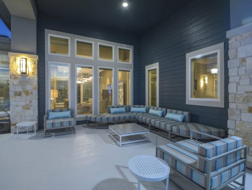Modern patio lounge with cushioned seating, side tables, and a warm, well-lit setting for evening relaxation.