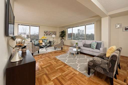 A living room with a grey couch and a wooden floor.