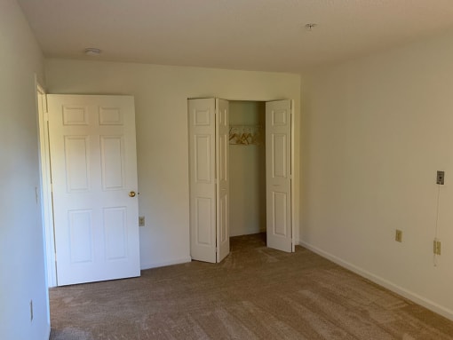 A beautifully-appointed bedroom with a carpeted floor.