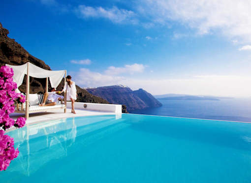 a woman standing next to a pool with a view of the ocean
