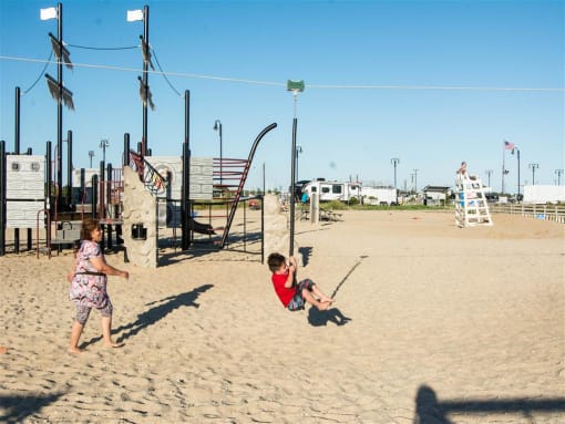 Boy swinging on a swing at the beach at Brookwood at Bay Shore in Bay Shore, NY 11706