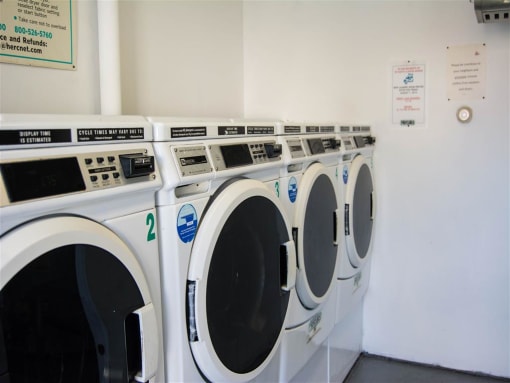 Row of washing machines in a laundry room at Brookwood at Bay Shore in Bay Shore, NY 11706