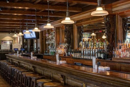 Classic bar with wood counter and pendant lighting at The Brook At Columbia Apartments, Columbia