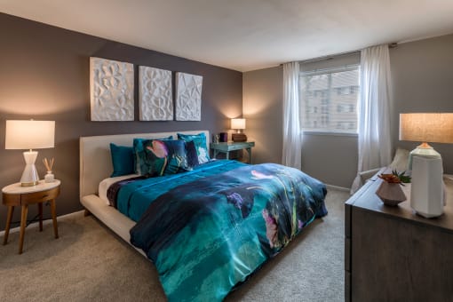 Bedroom with teal bedding and contemporary decor at The Brook At Columbia Apartments, Maryland